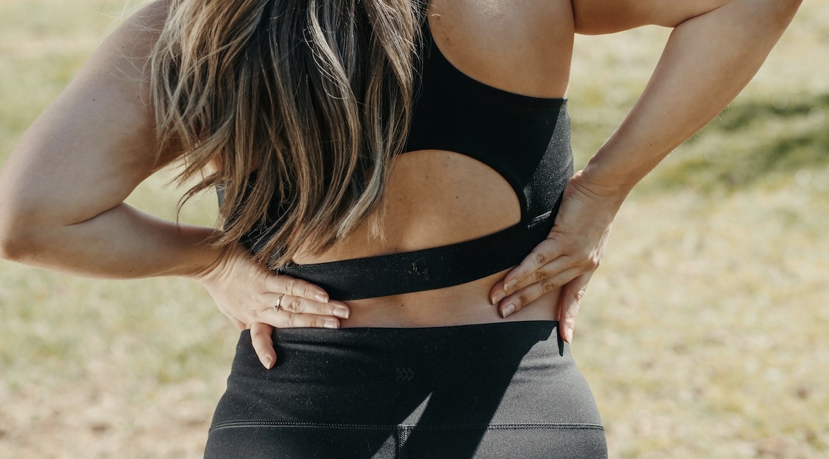 Woman holding back with backpain. Image: Pexels - Kindel Media