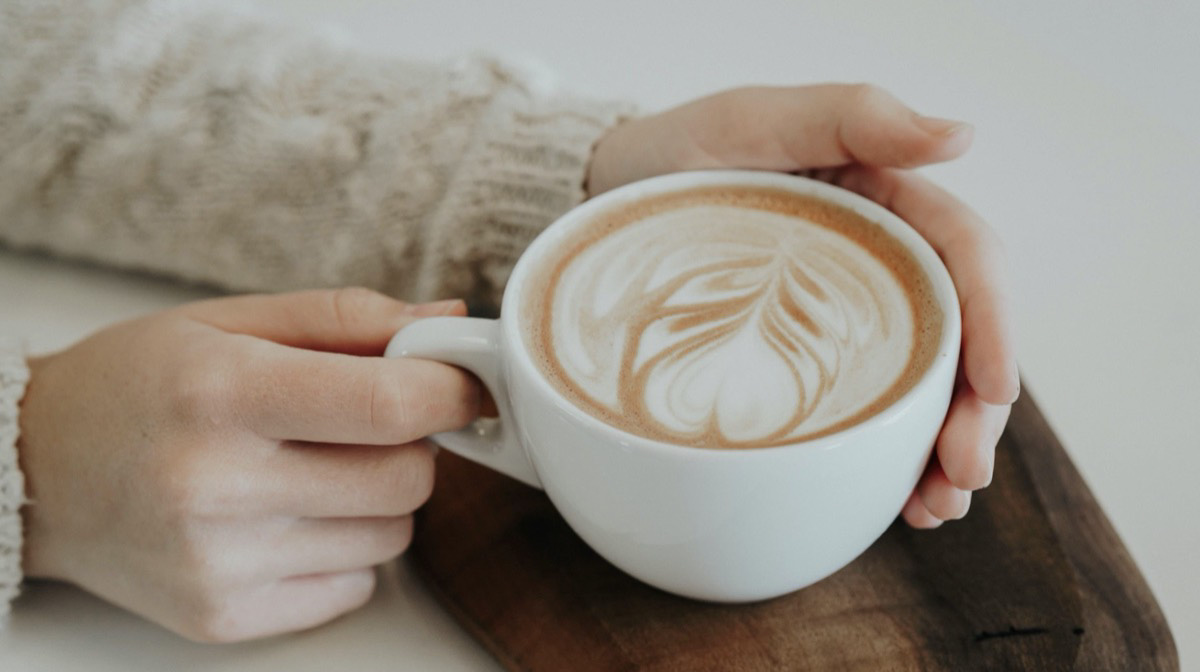 Woman holding a cup of coffee. Unsplash - Christiana Rivers