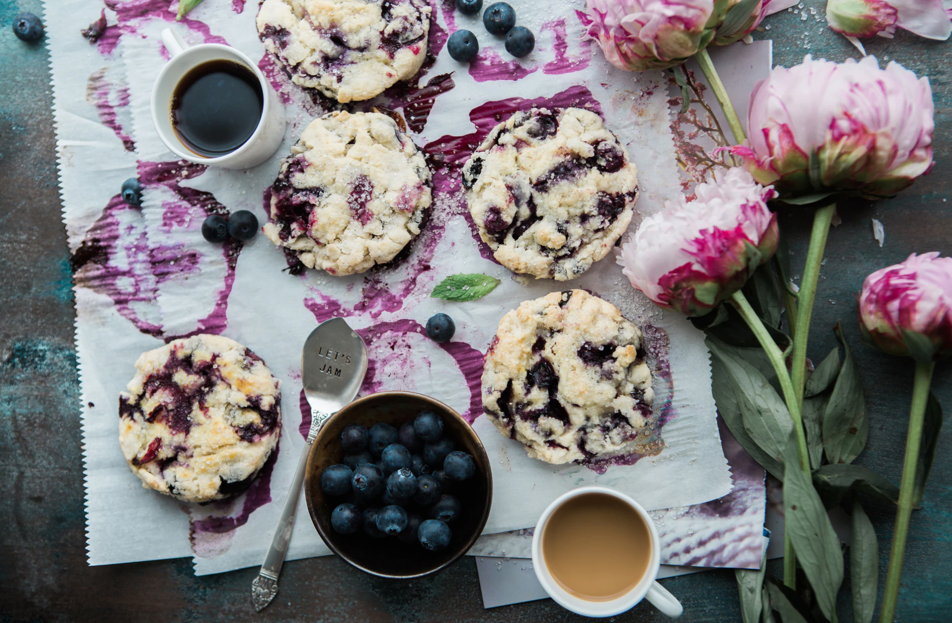 A plate of cranberry and blueberry cookies with peonies