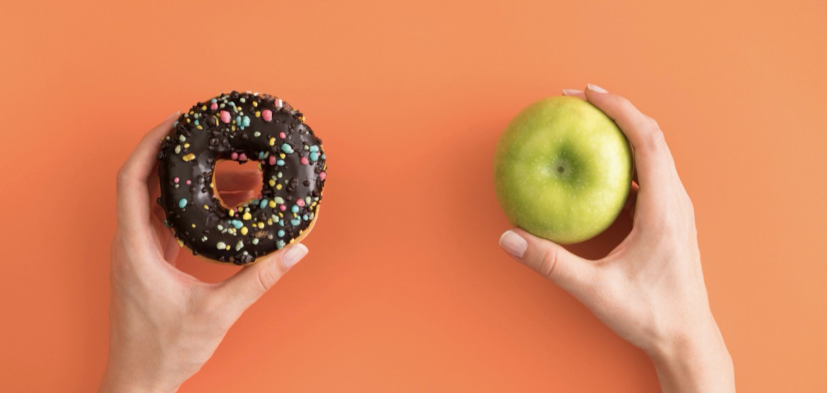 Holding a donut and an apple