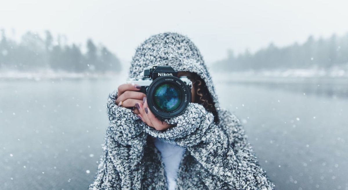 Woman taking a picture in the snow