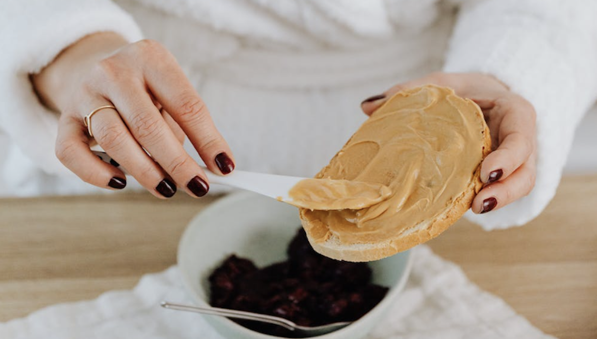 Woman making a peanut butter toast