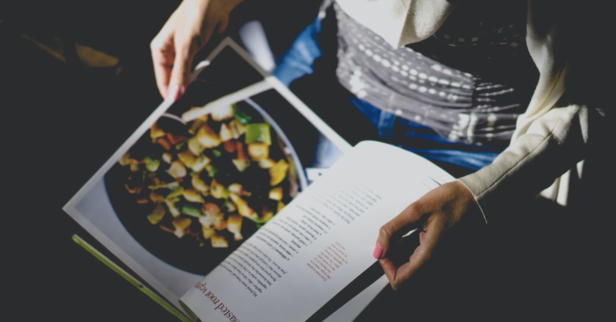 Woman looking through recipe book.