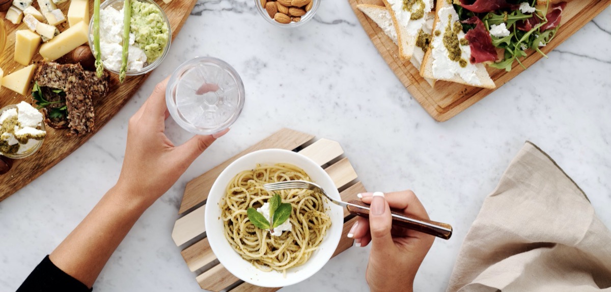 Woman eating a bowl of food with other meals around here. 