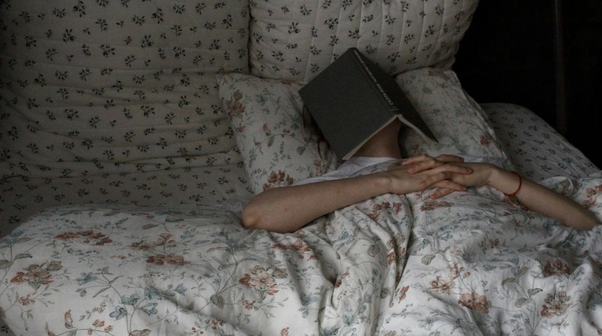 Sleeping with book on face. Image - Pexels: Deniz Kyzyltoprak